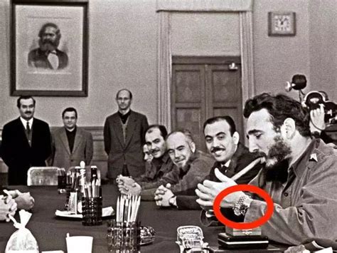 PHOTO: Fidel Castro, wearing two Rolexes, lighting a cigar while 